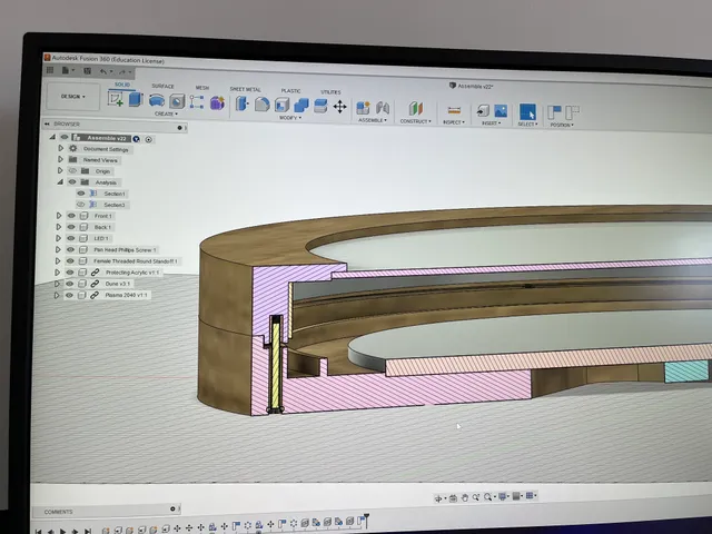 Fusion 360 section view showing the lamp's layered wooden frame and fasteners