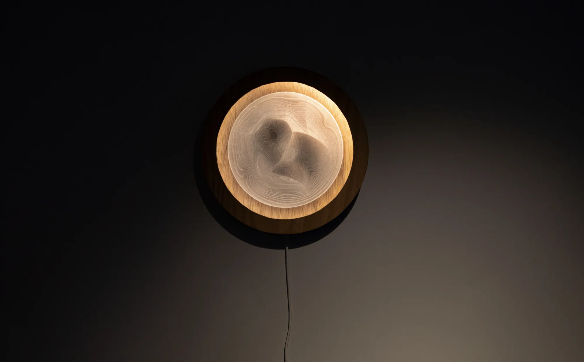 front view, round lighting fixture in a dark place, center shaped like mountains or dune