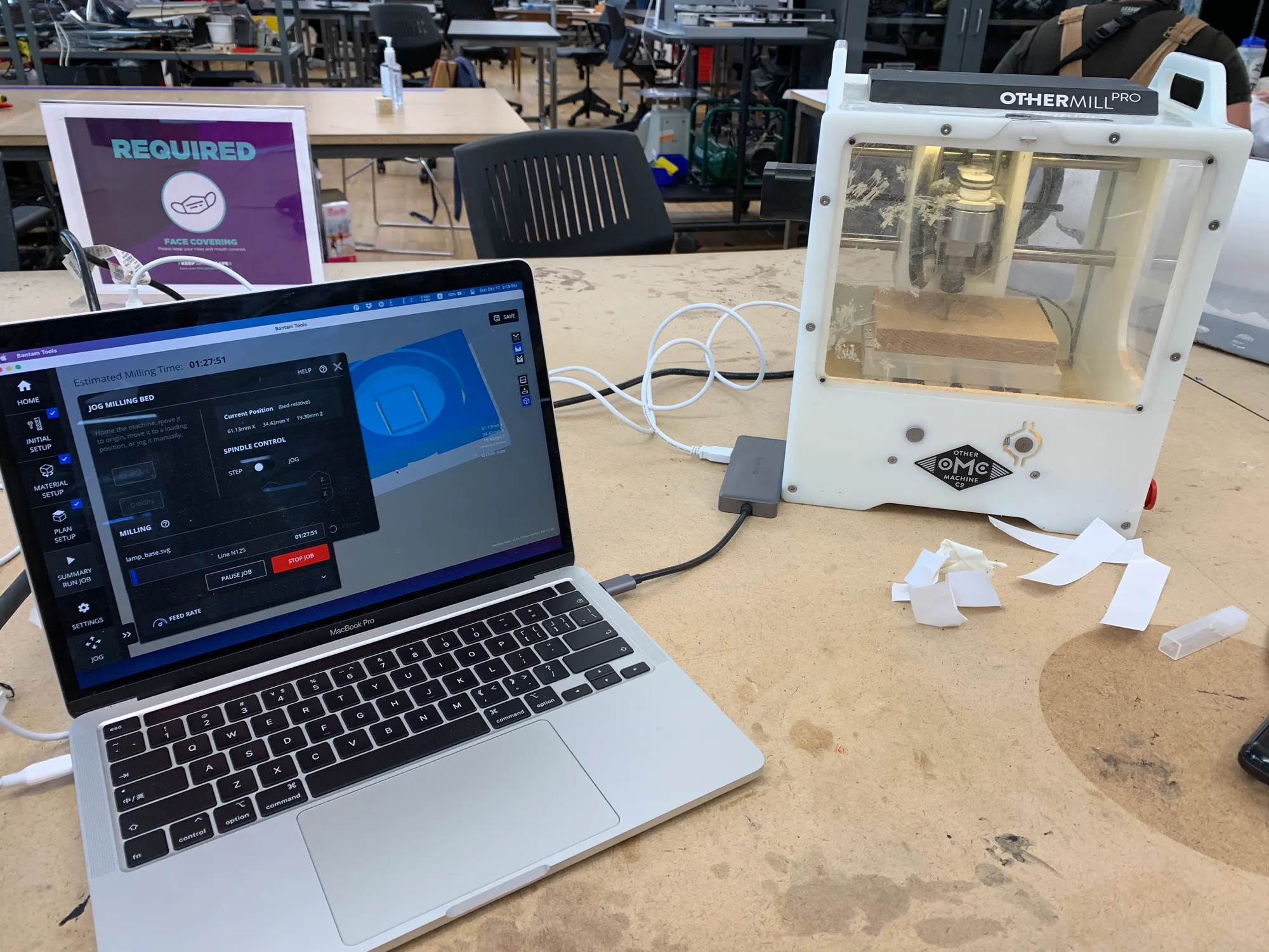 othermill cnc machine milling a piece of oak, computer next to it showing its progress